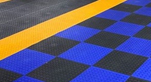 Wearwell's blue and black ErgoDeck matting installed to designate different workspaces in the plant.