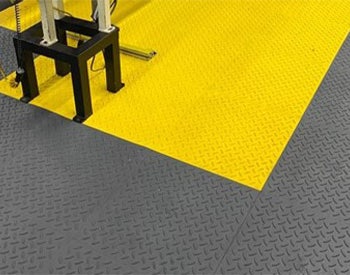 Wearwell's ErgoDeck Diamond-Plate installed to prevent accidents and support workers and the machines.