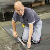 Man measuring and cutting matting